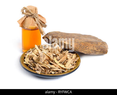 Legno di agar, chiamato anche aloeswood oudh. Con olio essenziale in bottiglia farmaceutica. Isolato su sfondo bianco. Foto Stock