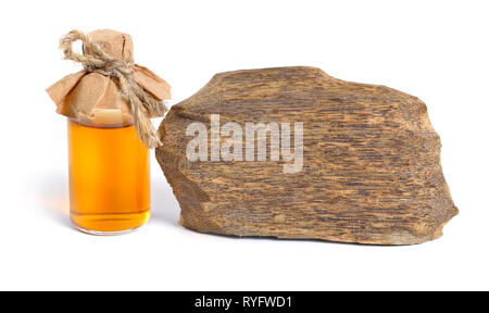 Legno di agar, chiamato anche aloeswood oudh. Con olio essenziale in bottiglia farmaceutica. Isolato su sfondo bianco. Foto Stock