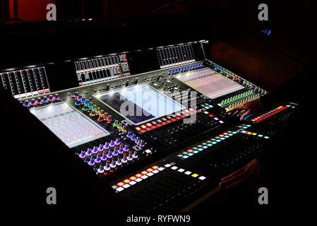 Maschio sono le mani su un Professional digital mixing console per il controllo del suono in uno studio di registrazione Foto Stock