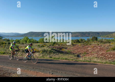 Due ciclisti equitazione biciclette lungo il Lago di Dammed Lac du Salagou (sud della Francia). Foto Stock