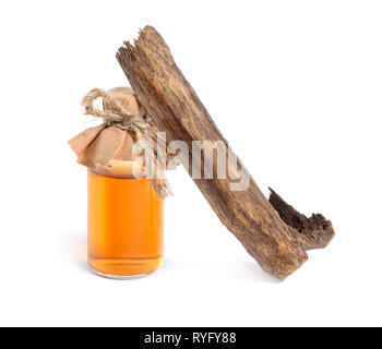 Legno di agar, chiamato anche aloeswood oudh. Con olio essenziale in bottiglia farmaceutica. Isolato su sfondo bianco. Foto Stock