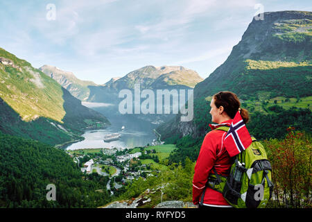 Uno zaino in spalla turistico guarda su Geirangerfjord dal punto di vista Flydalsjuvet a Geiranger, Sunnmøre, Møre og Romsdal, Norvegia, Scandinavia - in touring Foto Stock