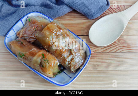 Farcite involtini di cavolo ripiene di carne e riso con verdure in foglie di cavolo su un vecchio tavolo di legno. Foto Stock