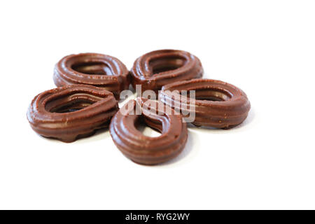 Piccolo cioccolato frittelle di spagnolo a forma di fiore su sfondo bianco Foto Stock