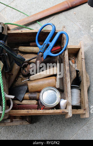 Le attrezzature utilizzate per le operazioni manuali di suola di calzatura sticthing memorizzato in un carrello di legno. Foto Stock