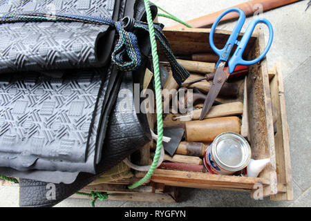 Le attrezzature utilizzate per le operazioni manuali di suola di calzatura sticthing memorizzato in un carrello di legno. Foto Stock