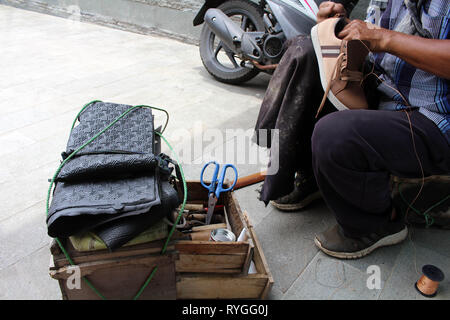 Processo di scarpa manuale Riparazione, suola e welt di fissaggio e di cucitura. Preso in Indonesia. Foto Stock