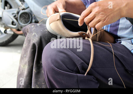 Processo di scarpa manuale Riparazione, suola e welt di fissaggio e di cucitura. Preso in Indonesia. Foto Stock