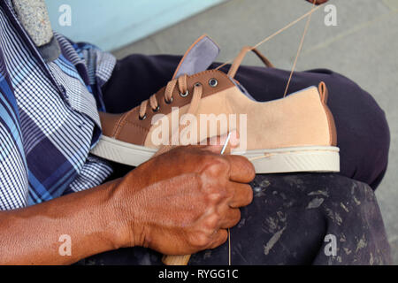 Processo di scarpa manuale Riparazione, suola e welt di fissaggio e di cucitura. Preso in Indonesia. Foto Stock