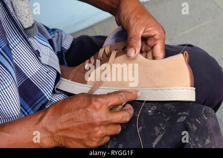 Processo di scarpa manuale Riparazione, suola e welt di fissaggio e di cucitura. Preso in Indonesia. Foto Stock