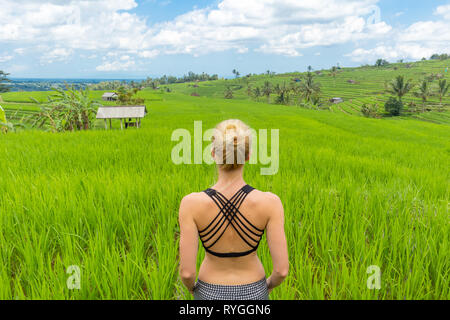 Rilassato e informale donna sportivo godendo di pura natura di splendidi e verdi risaie di Bali. Foto Stock