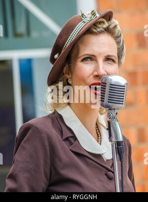 Woodhall Spa 1940 Festival - donna nel tradizionale 1940s dress cantando Foto Stock