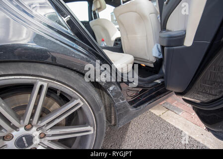 Car crash UK. Chiudere la riparazione del danno e dettagli dopo un incidente stradale. Carrozzeria frantumato e pneumatici. Foto Stock