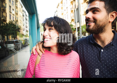 Felice e attraente coppia giovane guardando vetrine sorridente Foto Stock