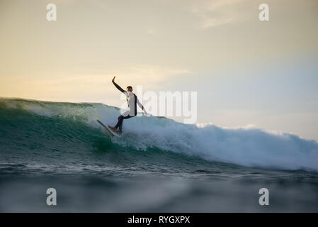 Surfer cavalcando le onde sull'isola di Fuerteventura nell'Oceano Atlantico Foto Stock