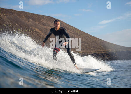 Fuerteventura - Marzo 01, 2019: surfer cavalcando le onde sull'isola di Fuerteventura nell'Oceano Atlantico Foto Stock