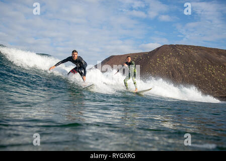 Fuerteventura - Marzo 01, 2019: surfer cavalcando le onde sull'isola di Fuerteventura nell'Oceano Atlantico Foto Stock