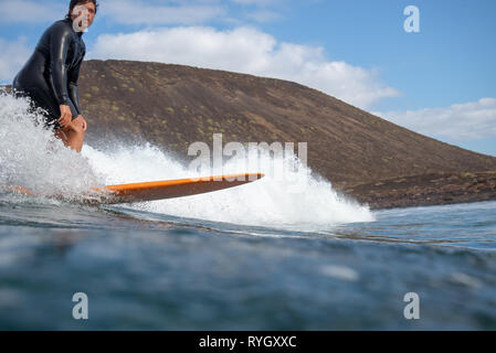 Fuerteventura - Marzo 01, 2019: surfer cavalcando le onde sull'isola di Fuerteventura nell'Oceano Atlantico Foto Stock