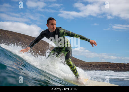 Fuerteventura - Marzo 01, 2019: surfer cavalcando le onde sull'isola di Fuerteventura nell'Oceano Atlantico Foto Stock