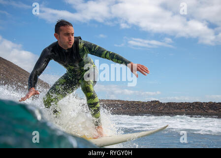 Fuerteventura - Marzo 01, 2019: surfer cavalcando le onde sull'isola di Fuerteventura nell'Oceano Atlantico Foto Stock