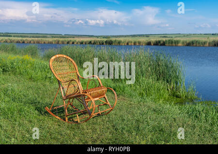 In vimini vuota dondolo su una Sura riverside attesa per qualsiasi essere umano per rilassarsi Foto Stock