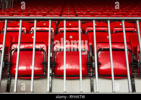 Righe di numerati lucido pieghevole in plastica rosso posti a sedere per i tifosi sulle terrazze del cavalletto principale a Liverpool Football Club di Anfield Road Stadium, LANCASHIRE REGNO UNITO. Foto Stock