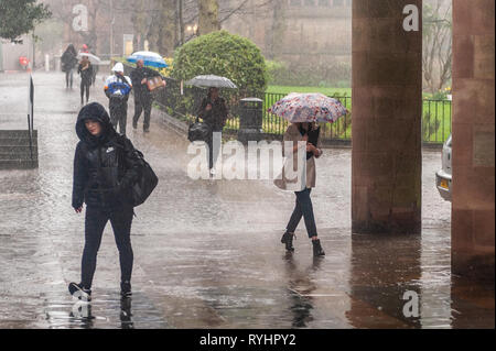 Coventry, West Midlands, Regno Unito. Il 14 marzo 2019. Persone corsa di lavorare sotto una pioggia torrenziale che ha colpito il Coventry questa mattina. Ci saranno le docce e il sole per il resto della giornata. Credito: Andy Gibson/Alamy Live News. Foto Stock