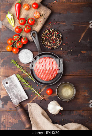 Crudo fresco sminuzzato in casa gli agricoltori grill hamburger di manzo in padella con le spezie e le erbe aromatiche e le carni hatchet sulla tavola di legno. Foto Stock