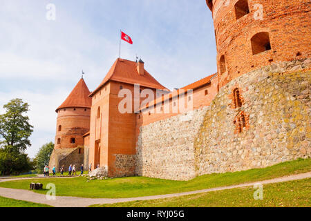 Trakai, Lituania - 16 Settembre 2015: persone che entrano Trakai Island Castle attraverso il cancello principale. Ingresso e torri angolari di Trakai Island Castle Foto Stock