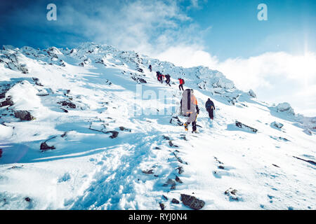 Un gruppo di alpinisti ascendente di una montagna in inverno Foto Stock