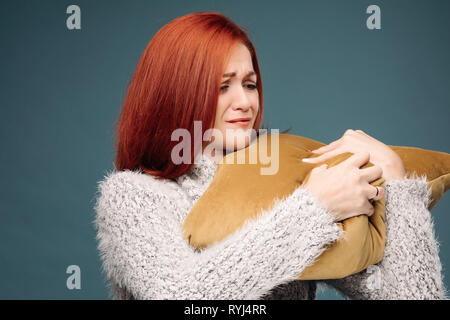 Ill donna avente terribile mal di testa e tenendo la mano sul avambraccio. Foto Stock