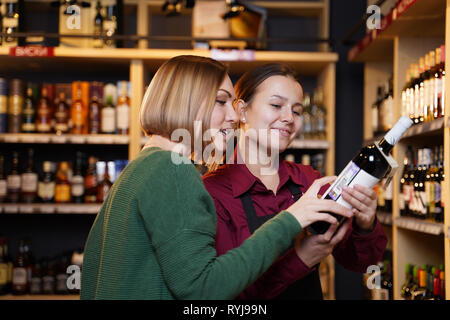 Foto di due donne con una bottiglia di vino Foto Stock