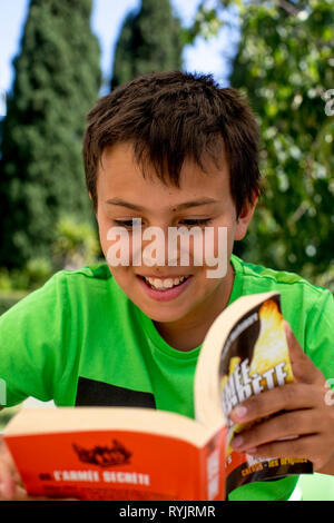 12-anno-vecchio ragazzo leggendo un libro in Sicilia (Italia). Foto Stock