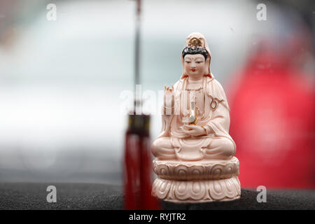 Quan Am, il Bodhisattva della compassione o della Dea della Misericordia. Talismano di protezione in un'auto. Ho Chi Minh City. Il Vietnam. Foto Stock