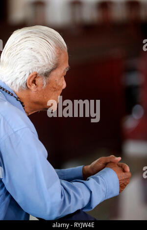 Il vecchio uomo in preghiera nella chiesa. Vung Tau. Il Vietnam. Foto Stock