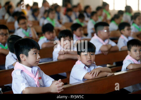 Bambini cristiani alla domenica mattina catholic mass. Chau Doc chiesa. Il Vietnam. Foto Stock