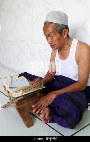 Jamiul Azhar moschea. Uomo musulmano la lettura di un vecchio Corano. Chau Doc. Il Vietnam. Foto Stock