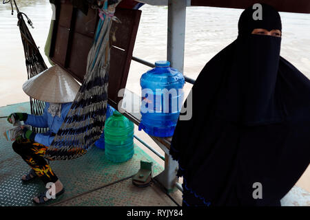 La donna musulmana che indossa il hijab e vietnamita donna che indossa il tradizionale cappello conico. Chau Doc. Il Vietnam. Foto Stock