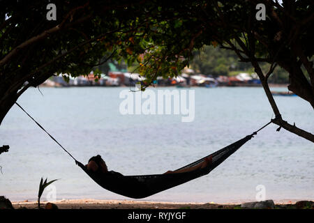 Sul mare del sud della Cina. Donna relax su una spiaggia in un'amaca. Ha Tien. Il Vietnam. Foto Stock