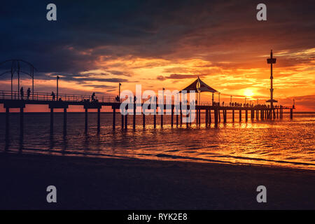 Iconici molo di Brighton con persone sagome godendo tramonto spettacolare, Sud Australia Foto Stock