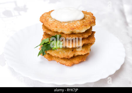 Fritti frittelle di patate al prezzemolo sulla piastra bianca Foto Stock