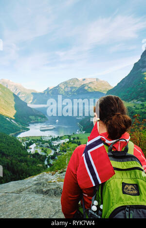 Uno zaino in spalla turistico guarda su Geirangerfjord dal punto di vista Flydalsjuvet a Geiranger, Sunnmøre, Møre og Romsdal, Norvegia, Scandinavia - in touring Foto Stock