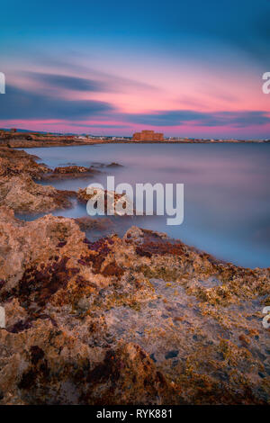 Bella lunga esposizione tramonto colpo di un paesaggio marino vista di Paphos il castello medievale e il mare Foto Stock