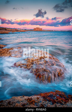 Bella lunga esposizione tramonto colpo di un paesaggio marino vista di Paphos il castello medievale e il mare Foto Stock