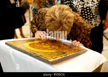 Celebrazione della mirra portatori' domenica in Nazareth (melkita cattolica greca) Chiesa, della Galilea, Israele. Donna baciare una Vergine Maria icona. Foto Stock