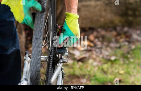 Uomo che pulisce la sua bicicletta per la nuova stagione di guida Foto Stock