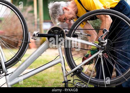 L'uomo mantenendo la sua bicicletta per la nuova stagione di guida Foto Stock