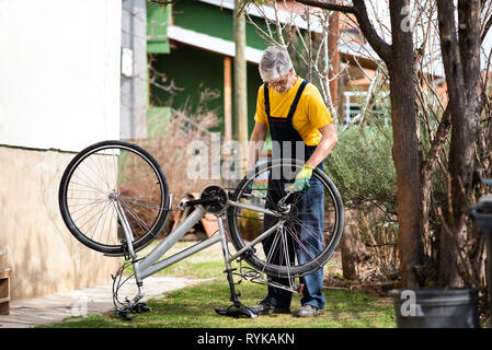 Uomo di lubrificazione della catena di bicicletta e mantenendo per la nuova stagione Foto Stock