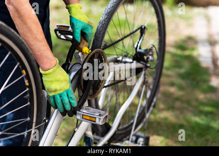 Uomo di lubrificazione della catena di bicicletta e mantenendo per la nuova stagione Foto Stock