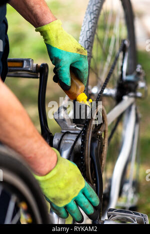 Uomo di lubrificazione della catena di bicicletta e mantenendo per la nuova stagione Foto Stock